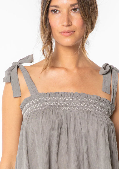 Woman modeling bohemian tie shoulder smocked tank top with tie-shoulder straps