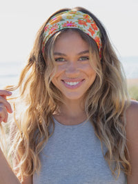 Woman modeling a Boho Bandeau headband with a rainbow floral design