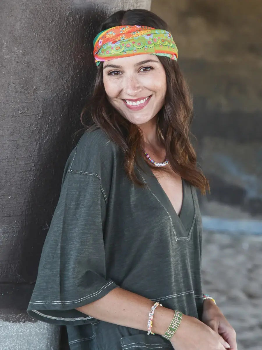 Woman smiling in a FULL BOHO BANDEAU HEADBAND, featuring an orange green border