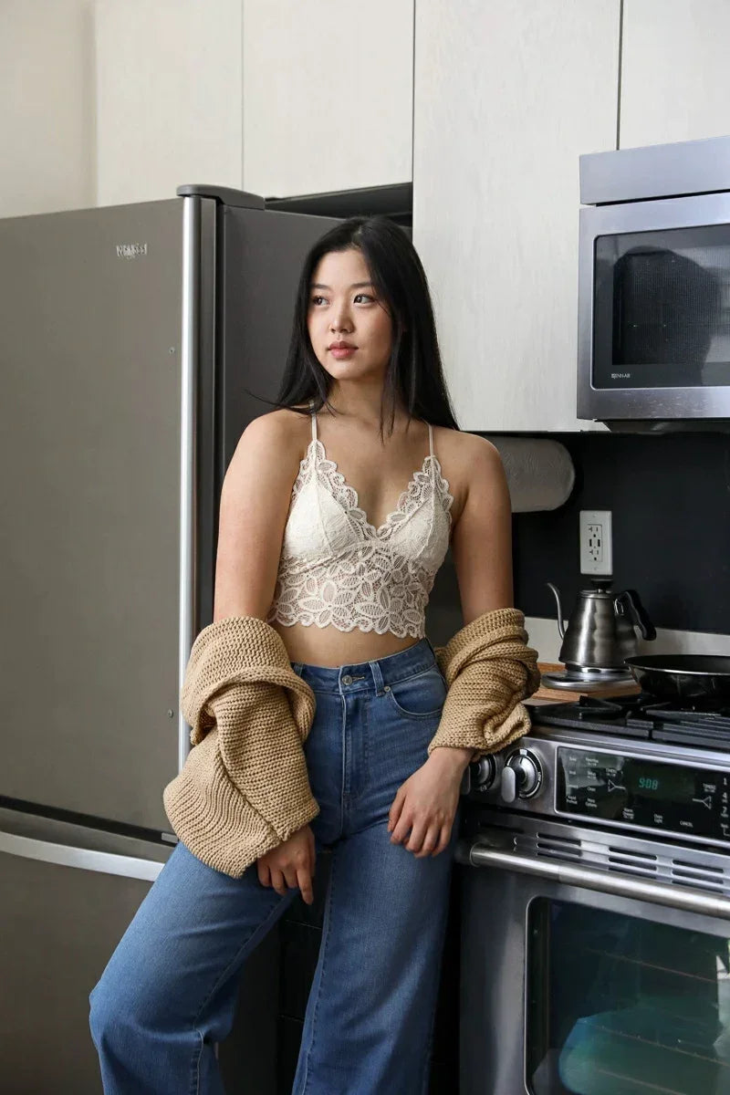 Woman sitting on kitchen counter showcasing RACERBACK FLOWER LACE BRALETTE PADDED as a major free spirit