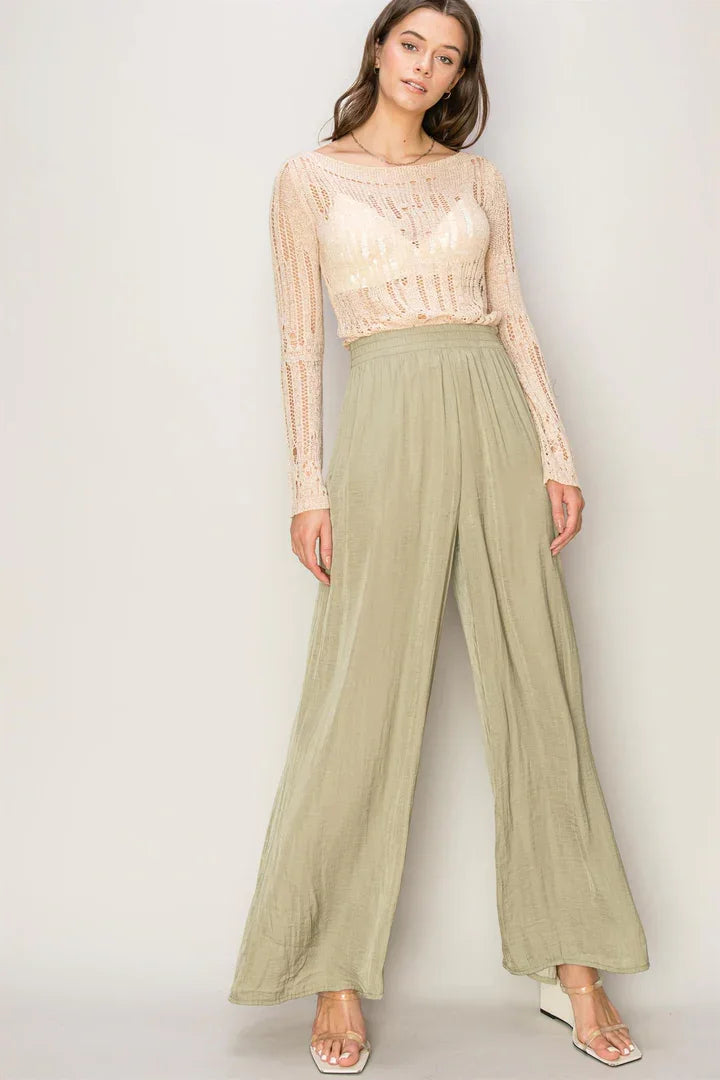 Woman in a lace top and flowy washed satin wide-leg sage green pants for a boho look