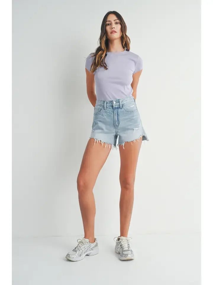 Woman in lavender t-shirt and denim shorts showcasing Vintage Frayed Hem Short Denim