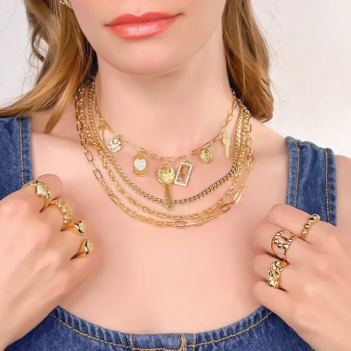 Woman wearing layered gold necklaces and resistant adjustable wrinkly gold rings