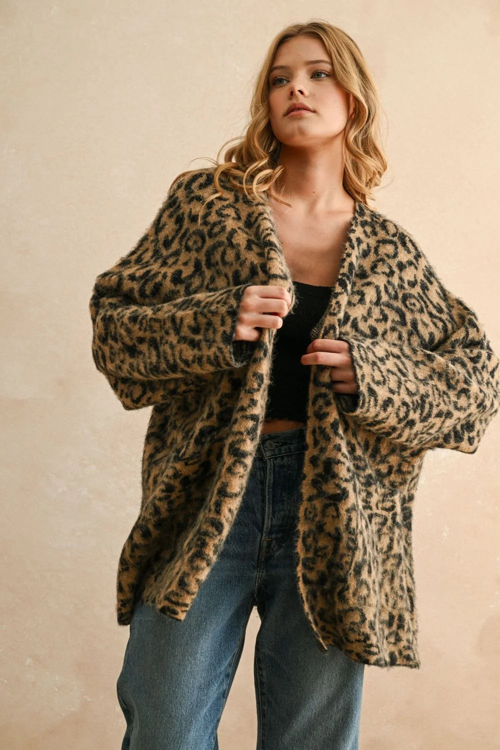 Woman wearing a leopard oversized cardigan with blue jeans for a stylish look