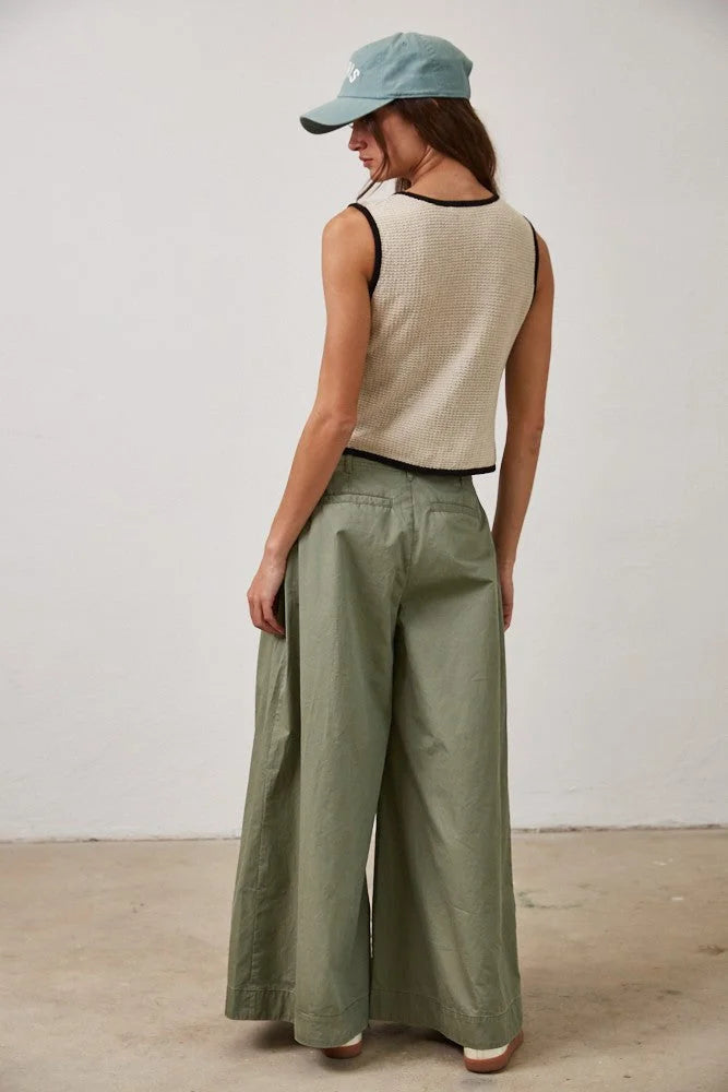 Woman in contrast linen cotton knitted tie front vest top, beige crop top, olive green pants