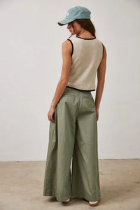 Woman in contrast linen cotton knitted tie front vest top, beige crop top, olive green pants