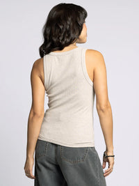 Woman modeling the Edlin Basic Tank in light beige with dark grey wide-leg pants