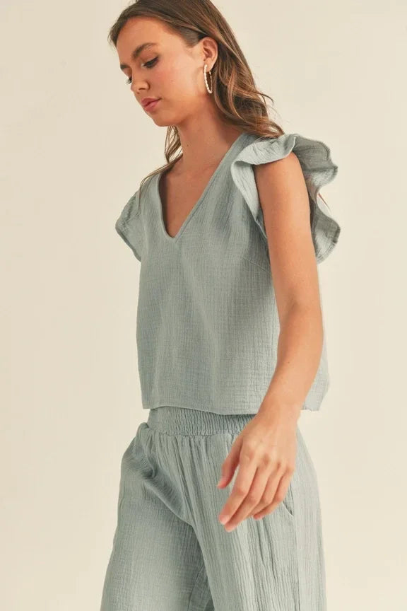 Woman in light blue double gauze ruffled sleeve top and matching pants