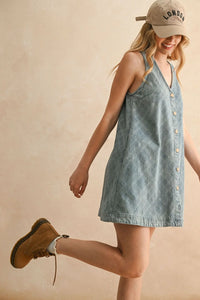 Woman modeling jacquard denim button front dress with beige London cap