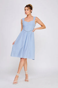 Woman in a light blue wash textured woven fitted dress showcasing elegant style
