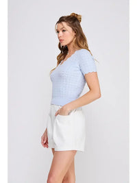 Woman wearing a light blue scallop edges knit top from Pointelle V-Neck collection, perfect for women’s boho chic clothing at Shop Daisy