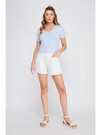 Woman wearing a light blue ribbed top with scallop edges in women’s boho chic clothing from Shop Daisy