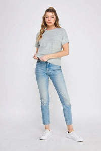 Woman in light blue jeans wearing a short sleeve patterned fine gauge knit dolman top