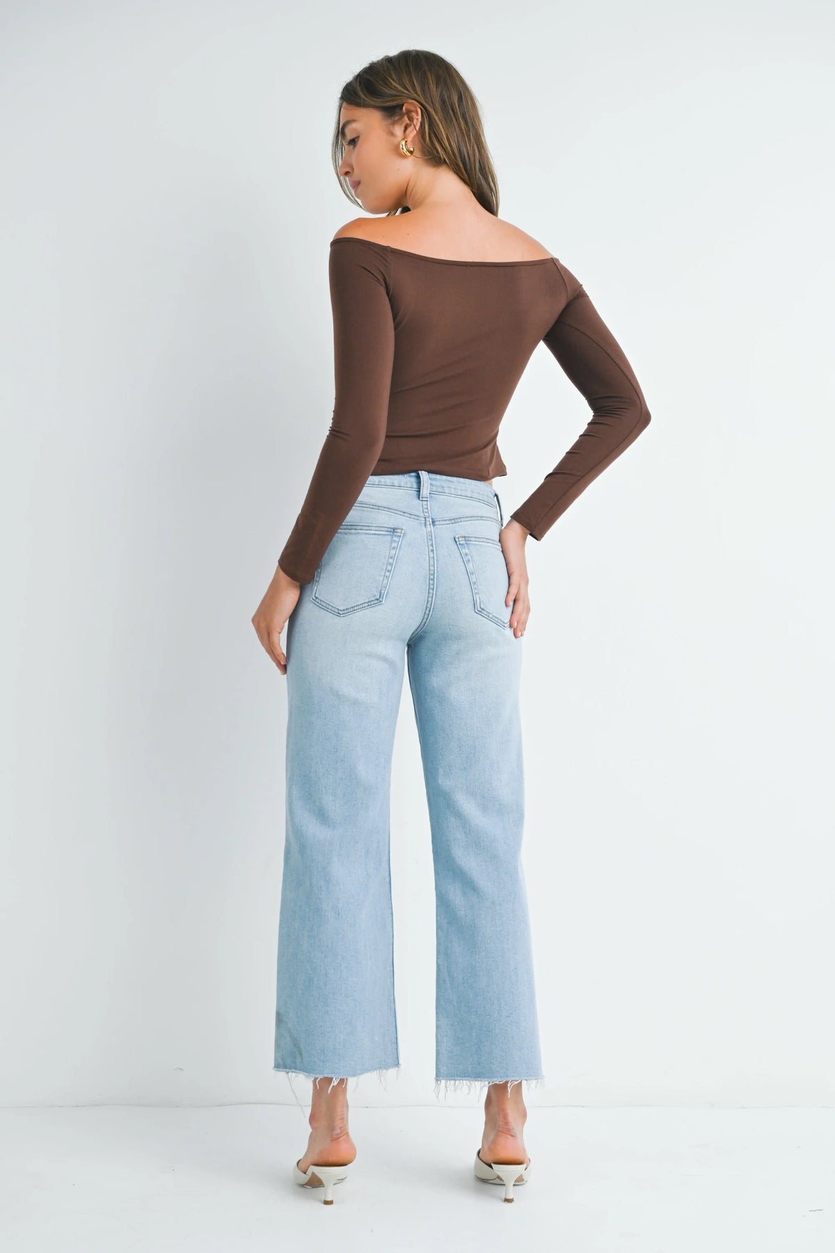 Woman in light blue jeans and brown off-shoulder top embodying boho free spirit style