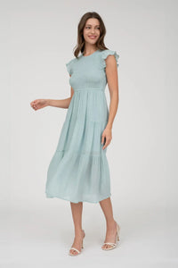 Woman in a light blue smocked tiered midi dress showcasing the SMOCKED TIERED MIDI DRESS style
