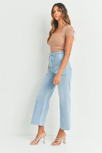 Woman in light blue jeans and tan top showcasing Women’s Boho Chic Clothing by Shop Daisy