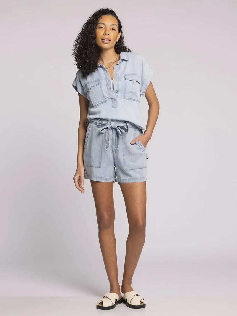 Woman wearing light blue denim Tencel Moore Top with flap pockets and versatile fits sizes