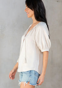 Floral puff sleeve button front top worn with distressed denim shorts by a woman