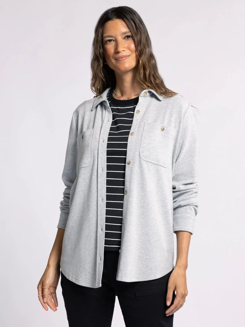 Woman in a light gray plush collared button down over a black and white striped top