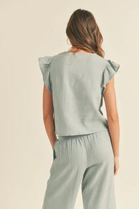 Woman in sage double gauze ruffled sleeve loungewear set, viewed from behind