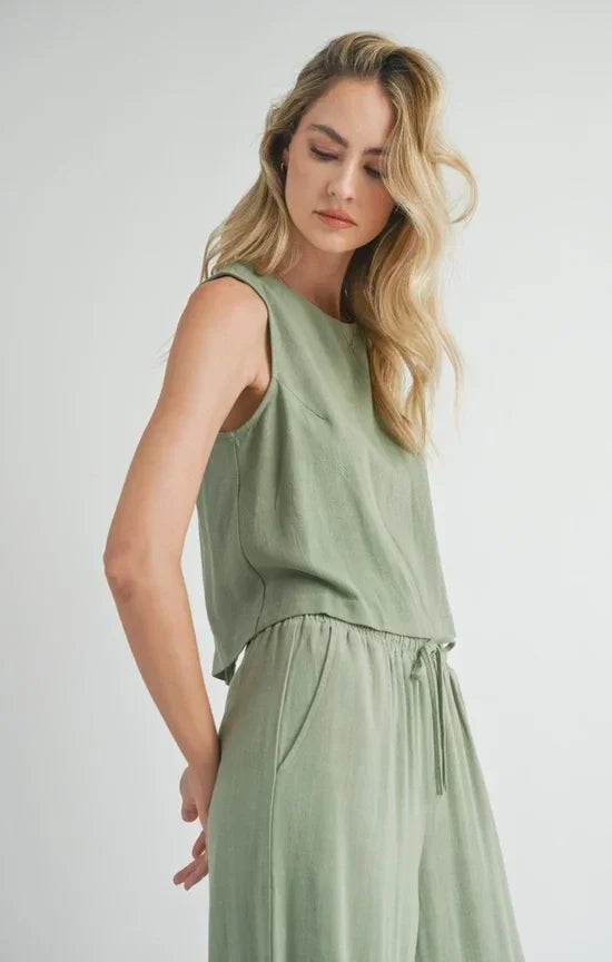 Woman in a light green sleeveless Sugarloaf Linen Tank with drawstring waist