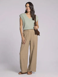Woman wearing light green top and tan linen women’s pants with elastic waistband