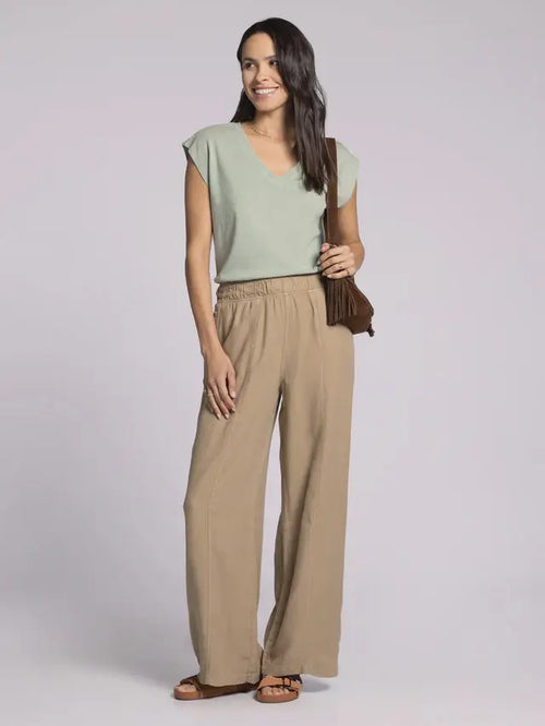 Woman wearing light green top and tan linen women’s pants with elastic waistband