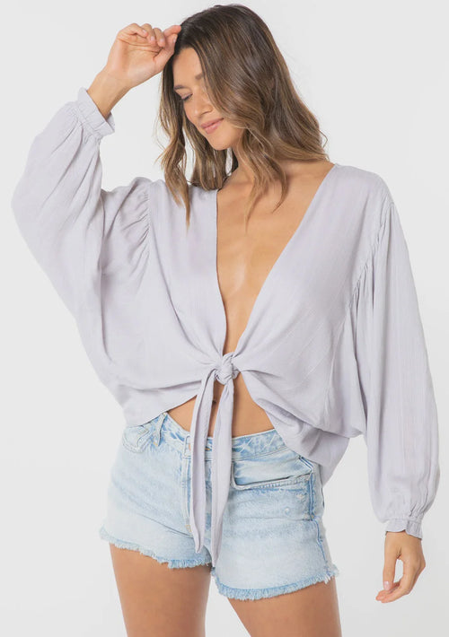 Woman wearing light grey jacquard stripe long sleeve kimono top and denim shorts