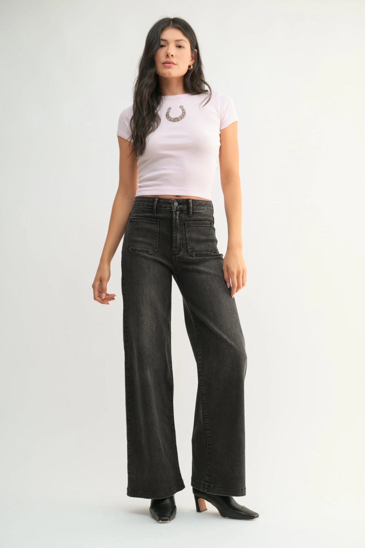 Woman wearing light purple cropped t-shirt with horseshoe graphic and patch pocket wide jeans