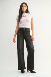 Woman wearing light purple cropped t-shirt with horseshoe graphic and patch pocket wide jeans