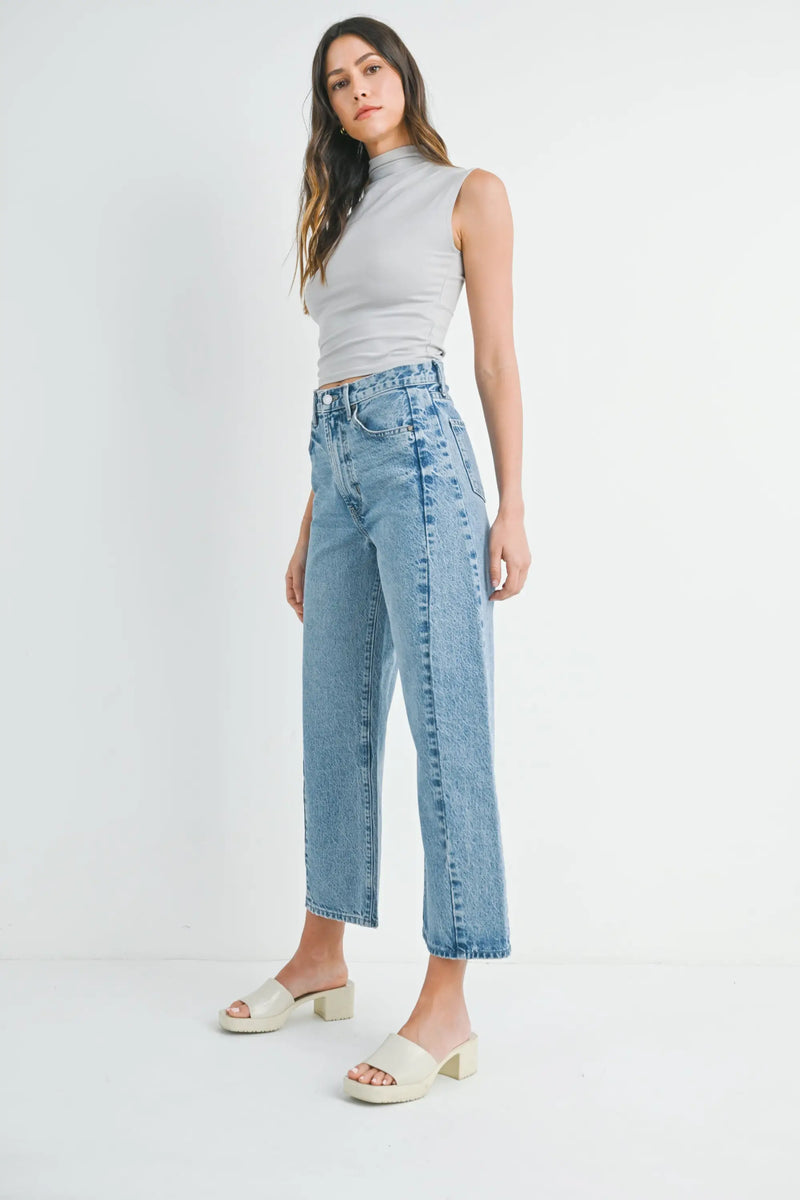 Woman in light-wash jeans and heeled sandals from Shop Daisy’s womens boho chic clothing