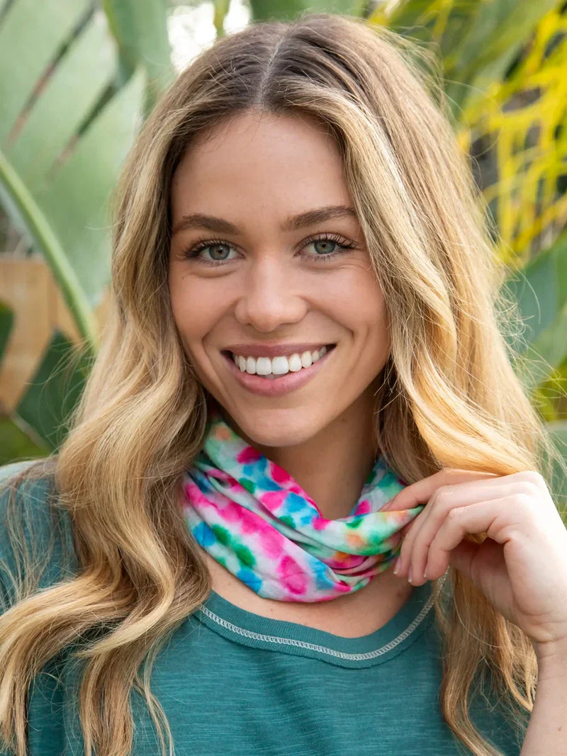 Smiling woman in teal top and colorful scarf models Boho bandeau headband