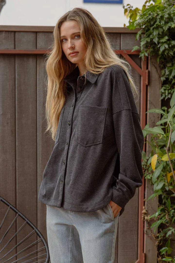 Woman with long blonde hair in an oversized pinstripe button down shacket