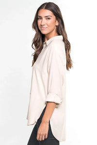 Woman wearing a bohemian long sleeve button down shirt with long sleeves and dark pants