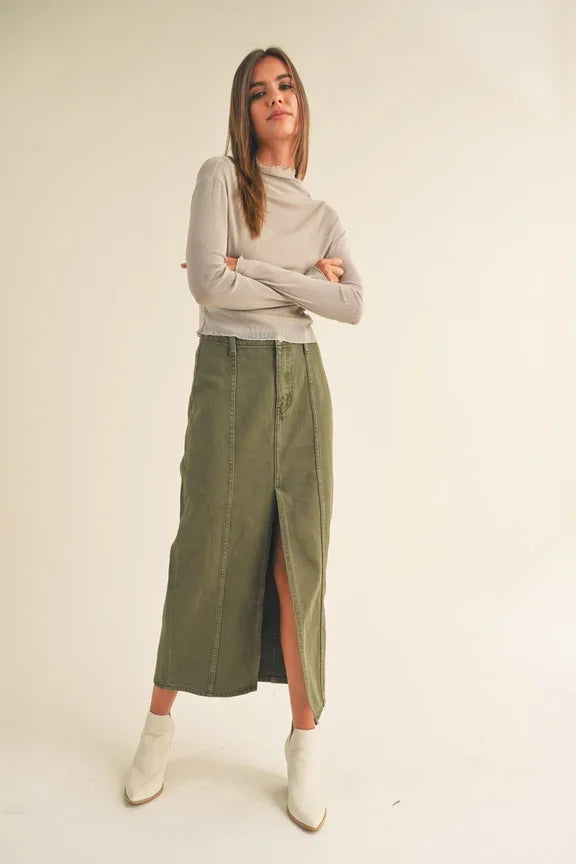 Woman in olive green skirt and cream long sleeve top from Shop Daisy’s women’s boho chic clothing