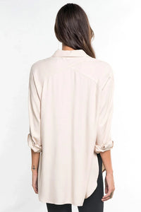 Woman from behind wearing bohemian long sleeve button-down shirt with cuffed sleeves