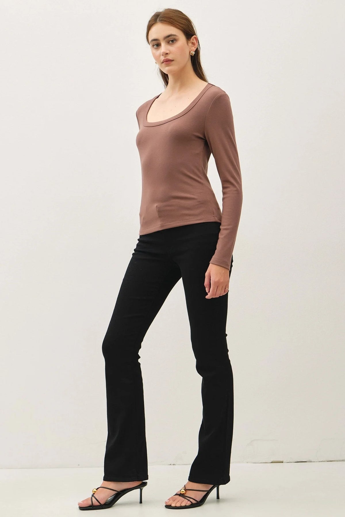 Woman wearing a basic scoop neck long-sleeve top with black flared pants and heels