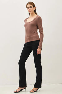 Woman wearing a basic scoop neck long-sleeve top with black flared pants and heels