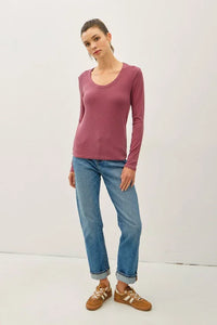 Woman wearing washed basic scoop neck ribbed shirt with light blue cuffed jeans and sneakers