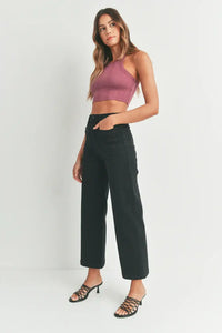 Woman in mauve crop top and black pants showcasing women’s boho chic sailor pocket wide leg jeans
