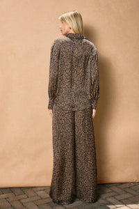 Woman wearing black and tan patterned sand pull drawstring pants with relaxed fit