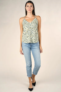 Woman wearing light blue cropped jeans and pale green animal print spaghetti strap tank