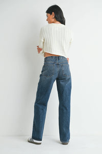 Woman modeling straight leg denim jeans with boho chic clothing and striped sneakers