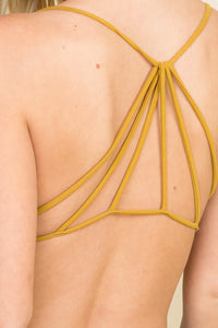 Woman in a mustard bralette, showcasing an effortlessly chic cross back design