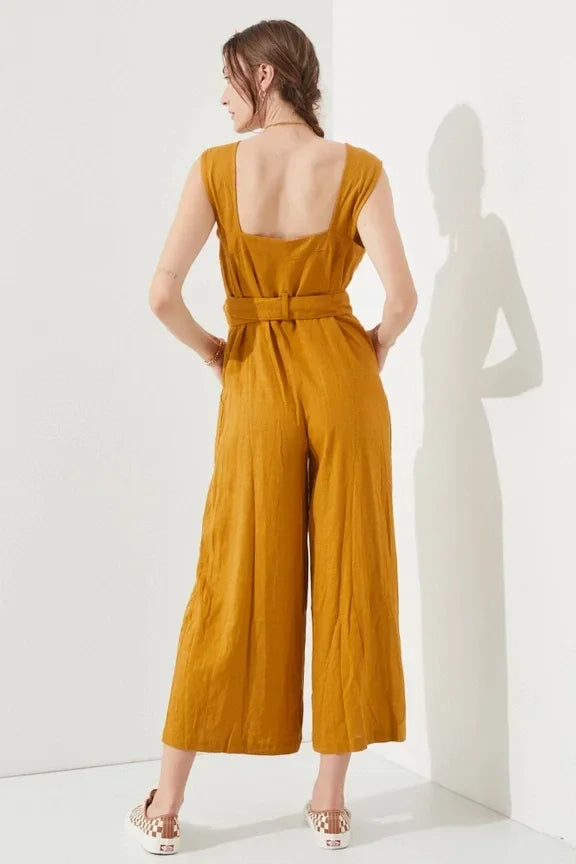 Woman modeling a stylish mustard sleeveless square neck button down ankle jumpsuit