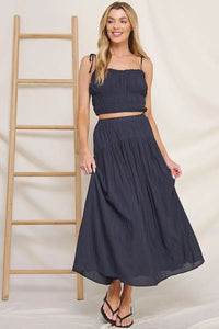 Woman in navy blue crop top and flowy crinkle sateen maxi skirt outfit