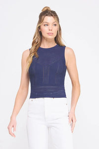 Woman wearing a navy blue fine gauge tank top with mixed pointelle detail and white jeans