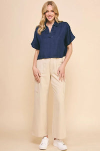 Woman in navy blue short-sleeved Washed Chambray Collared Relaxed Crop Top and beige pants