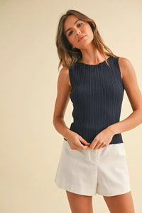 Woman wearing viscose ribbed knitted boho chic clothing in navy tank top and white shorts