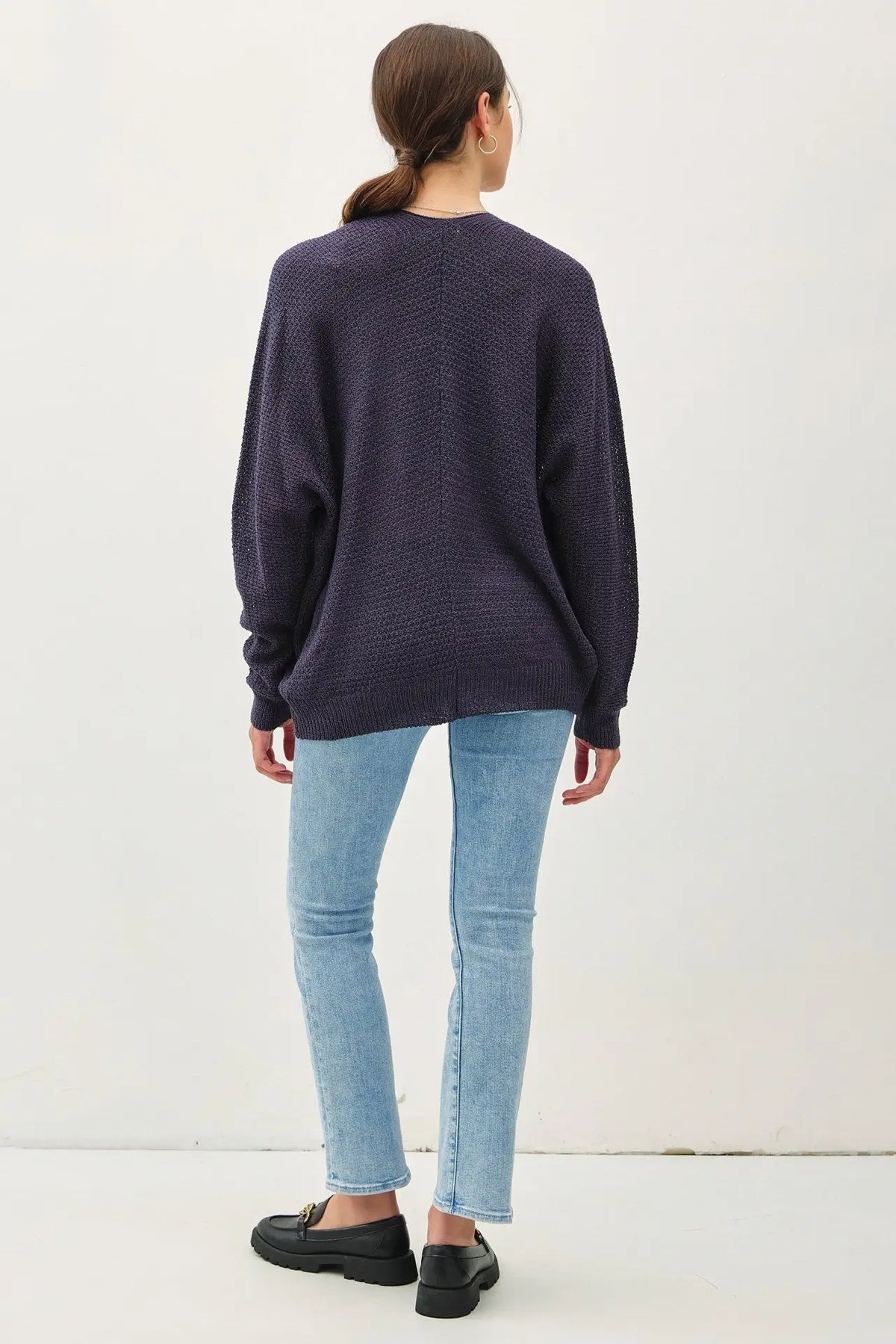 Woman wearing navy sweater and light blue jeans showcasing women’s boho chic clothing from Shop Daisy